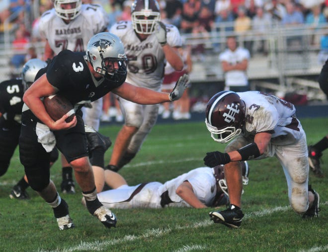 West Ottawa's Desmond Morgan stiff arms Holland Christian's Jeff Vroon (23) as he runs for a gain Thursday night at West Ottawa.
