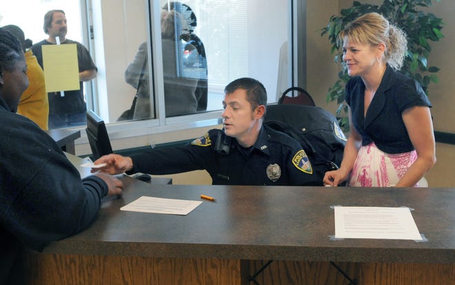 A client seeking financial assistance for a home heating bill receives a ticket from a Canton police officer to see a Stark County Community Action Agency intake counselor. The ticket serves to set an appointment for the client. In the past, those seeking assistance under the Home Energy Assistance Program would wait outside in the cold early in the morning until SCCAA would open its doors for the day.