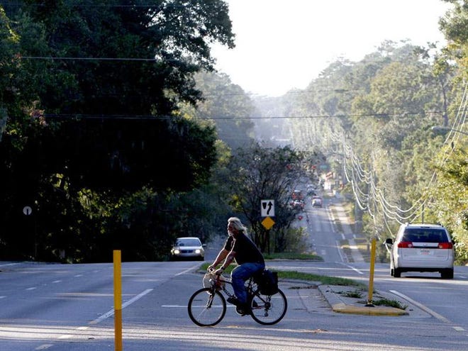 A bicyclist makes his way across Northwest 16th Avenue near Northwest 13th Street. The county is considering narrowing medians and closing median gaps.