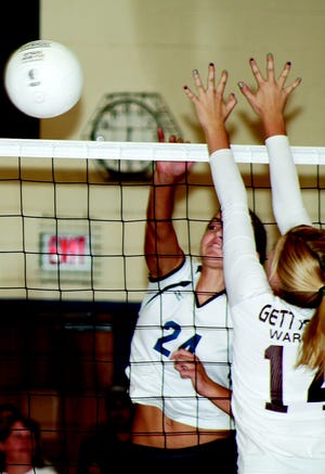 Nakita Gearhart delivers a hit against the block attempt.