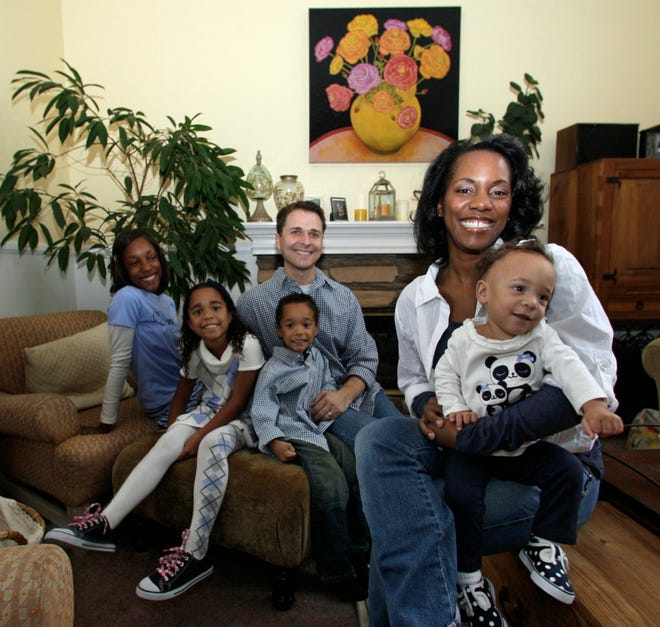 In this Oct. 30, 2010 photo, Christelyn Karazin holds her 15-month-old daughter, Emma, while her husband, Mike, sits with son Zachary, 5, daughter, Chloe, 7, and Kayla Higgins, 12, Christelyn's daughter, at their home in Temecula, Calif. Karazin had her first child with her boyfriend while she was in college; they never married. Her last three came after she married another man and became a writer and homemaker in an affluent Southern California suburb. In September, Karazin marshaled 100 other writers and activists for the online movement No Wedding No Womb, which she calls \u201Ca very simplified reduction of a very complicated issue." (AP Photo/Lenny Ignelzi)