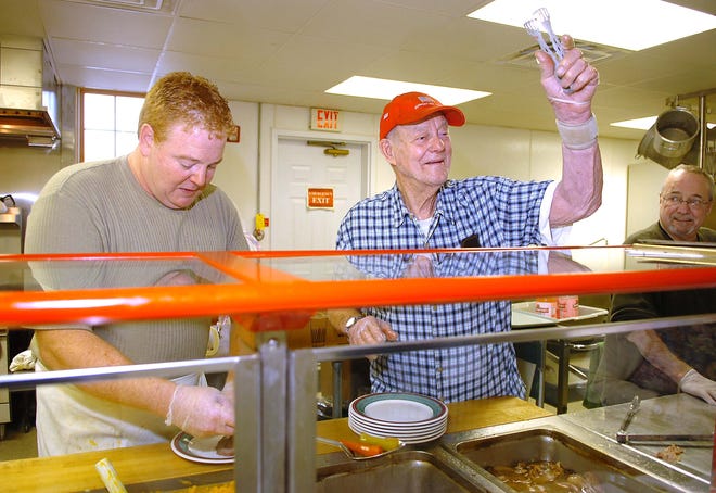 Frank Nelson, right, of West Bridgewater, 88, a veteran of World War II and Korea, serves lunch to the guests in the kitchen area with the help of Arthur Baldwin Jr. of West Bridgewater, who is the chef at the West Bridgewater Council On Aging.