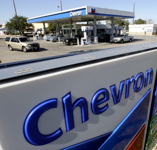 In this Jan. 8, 2009 file photo, motorists stop at a Chevron gas station in Houston. Chevron Corp. said Friday, May 1, 2009, first-quarter profit fell 64 percent as it, along with competitors, was stung by lower oil and natural gas prices.
