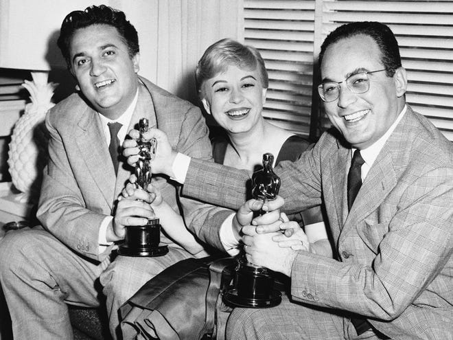 In this March 28, 1957 file photo, Federico Fellini, left, his wife Giulietta Masina, and Dino De Laurentiis hold the Oscars awarded for "La Strada" in the Hollywood section of Los Angeles, Calif. De Laurentiis, a film impresario and producer of "Serpico," "Barbarella" and "Death Wish," died Wednesday, Nov. 10, 2010 at his home in Beverly Hills, Calif. He was 91. (AP Photo/ Ellis Bosworth, File)