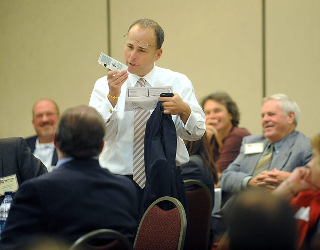 Jonathan Kraft, president of the New England Patriots, looks at tickets that he brought to be given away during the Marlborough Regional Chamber of Commerce's annual meeting luncheon Wednesday.