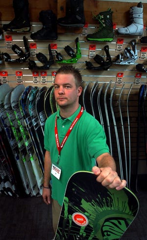 Store manager Tim May shows off the wide selection of snowboards at the new Sun & Ski Sports store in Pembroke.