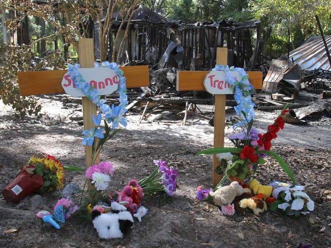 Crosses are shown in front of the Jordan home where, late Monday, five children died in a house fire in Citra.