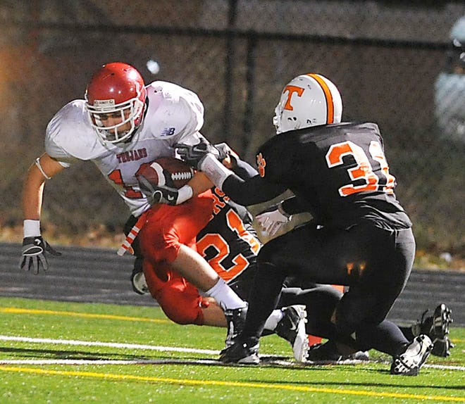 Bridgewater-Raynham ballcarrier Nick Schlatz is brought down by a pair of Taunton tacklers in Friday night's football win over Taunton.