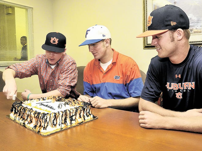 Lake Wales baseball players, Jarred Smith, left Justin Shafer, center, and Colton Davis cut the cake provided for a celebration held for the athletes on Friday at Lake Wales High School. Both Smith and Davis have signed with Auburn University and Shafer has signed with University of Florida. Thursday, November 12, 2010.