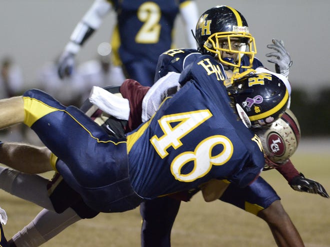 Winter Haven's Daniel Coyne and Donald Celisacar bring down Lake Gibson's Joseph Reynolds during Friday night's game at Denison Stadium in Winter Haven. Friday, November 12, 2010.