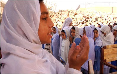 A fourth-grade Pakistani student leading a morning prayer at a Swat Valley school still in rubble from a Taliban bombing in 2007.