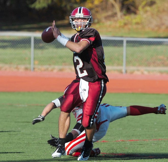 Brockton High School's quarterback Paul Mroz scrambles before throwing a pass in the second quarter.