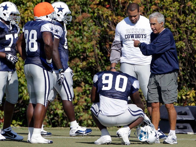 Dallas Cowboys newly hired defensive coordinator Paul Pasqualoni, right, gestures while instructing members of the defense before the start of a practice at the team’s training facility Wednesday in Irving.