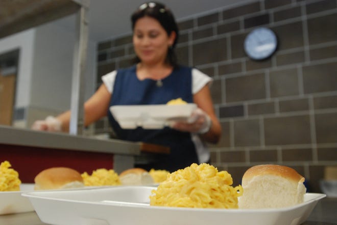 Jackie Hernandez, server at Jefferson Elementary School in Utica, puts food on trays Friday. The Utica school the district recently discovered a stash of the baked goods, along with other food, sitting in a cold storage warehouse in New Hartford.