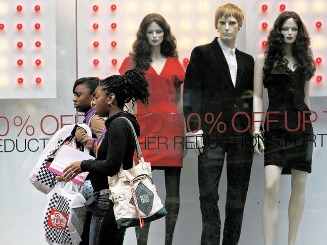 In this Dec. 21, 2009 file photo, women carry shopping bags as they walk past a French Connection UK store in San Francisco. As you head into the final stretch before the holiday rush and stores lose all subtlety in the ways they push gift-buying, you may wonder which bargains to snap up and which prices are likely to fall further.