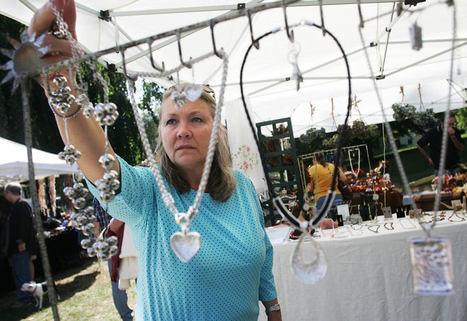 Barbie Chick of Holliston picks out a creative necklace made of silver from Heaven Sent Creations, from just one of many craft tents at the Holliston Harvest Fair at the Holliston Historical Society last year.