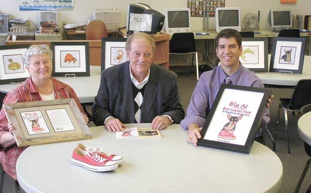 Kewanee native Ron Welch, center, now of Hayward, Wis., presented eight original hand-drawn watercolor illustrations used in his latest book, “Big Al & the Red Canvas Feet,” to the library at Central School Thursday. Also included were the red canvas sneakers he wore while writing the book which inspired the title. Accepting the gifts were librarian Anne Koepke and principal Jason Anderson.
