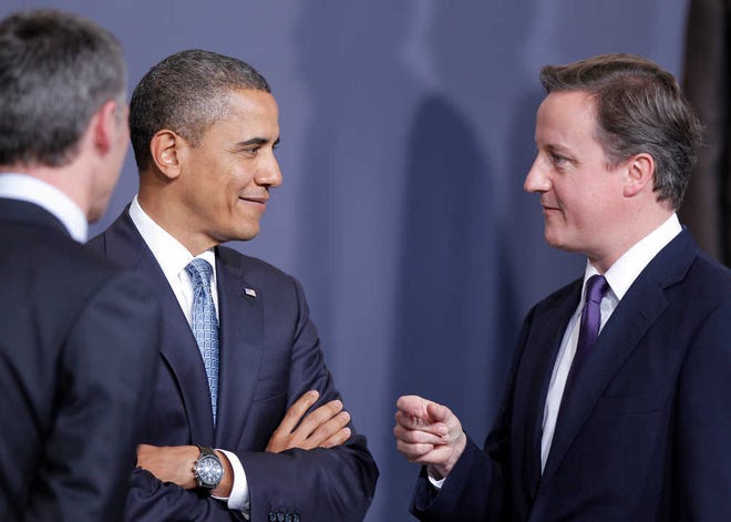 U.S. President Barack Obama and British Prime Minister David Cameron talk, watched by NATO Secretary General Anders Fogh Rasmussen, left, as they prepare for a group portrait at the Nato summit in Lisbon, Portugal Friday Nov 19 2010. Obama and the leaders of NATO's 27 other member nations opened a two-day summit Friday aimed at finding ways to keep the Cold War alliance relevant in the 21st century. (AP Photo/Daniel Ochoa de Olza)