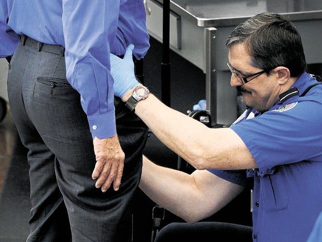 In this photo taken on Nov. 17, 2010, a Transportation Security Administration agent performs an enhanced pat-down on a traveler at a security area at Denver International Airport in Denver.