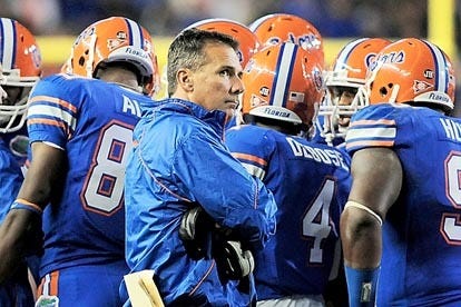 Florida coach Urban Meyer glances at the scoreboard in the fourth quarter as his team huddles on the sideline during last week's game against South Carolina in Gainesville.