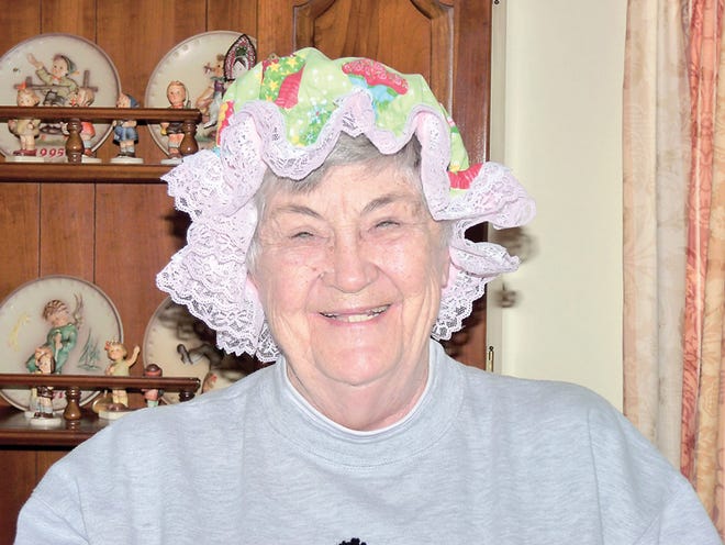Pat Heschle poses with one of her hats.