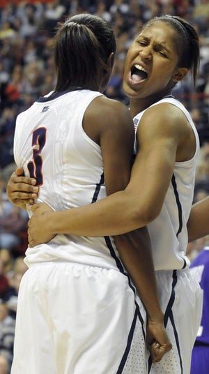 Connecticut's Maya Moore, right, celebrates with Tiffany Hayes (3) after Hayes made a basket and was fouled by a Holy Cross player during the first half of a NCAA college basketball game, in Storrs, Conn., Sunday, Nov. 14, 2010. Hayes had 30 points in the first half. (AP Photo/Jessica Hill)