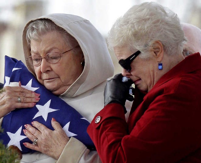 SACRIFICE REMEMBERED: Marie Hewitt Fromherz, left, mother of U.S. Marine Staff Sgt. Samuel Hewitt, clutches a flag after it was presented to her in a ceremony Friday in Rittman, Ohio. His sister, Paula Hewitt Banks, is at right. Hewitt was sent on patrol in Vietnam and never returned. His remains were found recently and returned to the family.