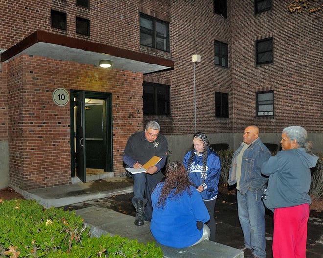 Worcester Fire Inspector Jose R. Machado, left, interviews Caroline Maldonado, seated, a resident of the apartment where the fire started, and Angelita Diaz, center, a second floor resident, and other residents of the Lakeside Apartments complex last night.