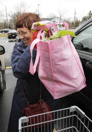 Barbara Redcay loads a reusable grocery bag into her car while shopping at a store in Clarence, N.Y., Wednesday.