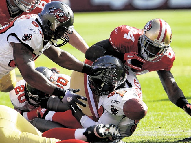 Tampa Bay Buccaneers linebacker Adam Hayward, left, reaches to recover a fumble by San Francisco 49ers wide receiver Josh Morgan (84) in the first quarter of an NFL football game, Sunday, Nov. 21, 2010, in San Francisco.