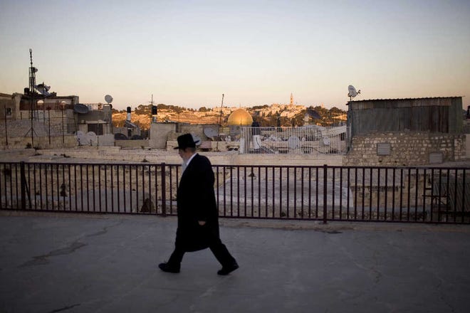 An ultra-orthodox Jewish man walks near the Dome of the Rock Mosque yesterday in Jerusalem’s Old City.