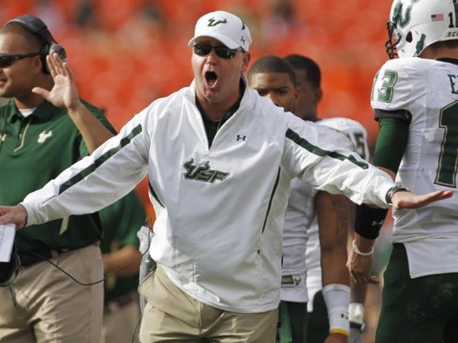 South Florida Coach Skip Holtz, center, protests a penalty call during the second half of the Bulls' 23-20 victory over the University of Miami on Saturday.