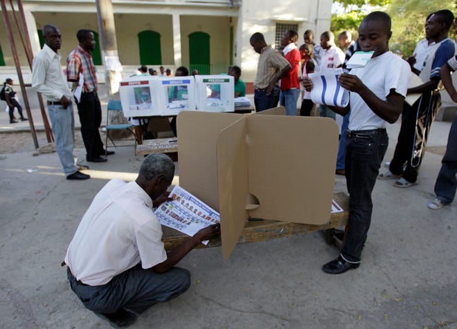 Voters check their ballots during the presidential and legislative elections in Port-au-Prince, Haiti, Sunday, Nov. 28, 2010. Haitians are going to the polls in the midst of a cholera epidemic that has killed more than 1,600 people and hospitalized thousands as it still recovers from the catastrophic Jan. 12 earthquake. (AP Photo/Andres Leighton)
