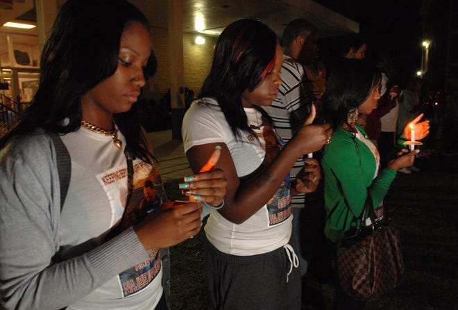 Malisha White (from left), Tiffany Tucker and Kasie Ber-Keys light candles Monday at Edward Waters College in the Student Union courtyard at a vigil for two students in a car accident last week. Najee Culmer died at the scene and Roberto Armenteros is still in a Miami hospital. Friends and classmates spoke of the pair fondly during the vigil.