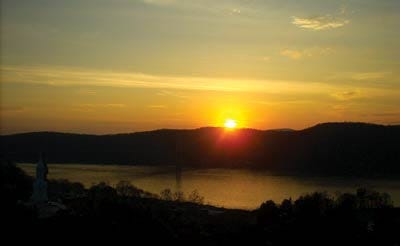 Photo by Stephanie Mostaccio/New Jersey Herald - The sun sets behind a mountain overlooking the Hudson River.