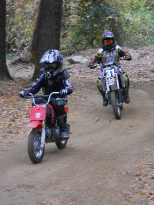 Youths ride on the dirt track on Thomas Stevens' property in Middleboro.