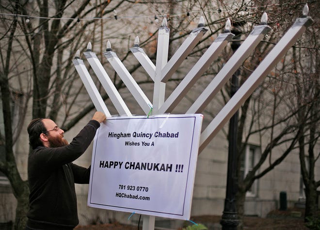 Rabbi Shmuel Bronstein prepares the large menorah in front of Quincy City Hall for the first night of Hanukkah, which starts at sundown tonight, Dec. 1.