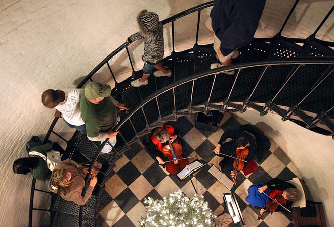 Visitors to the St. Augustine Lighthouse climb the spiraling staircase as The Anastasia String Quartet plays during luminary night on Wednesday. By DARON DEAN, daron.dean@staugustine.com