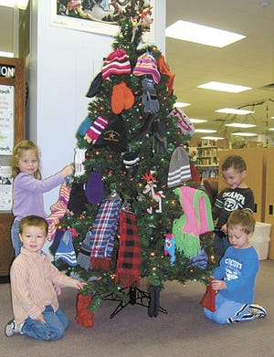 These four children added mittens and scarves to the Pontiac Public Library Christmas tree on Tuesday. At left are Hannah Ricketts, 4, and Henry Puryer, 3. At right are Duncan Eilts, 4, and Ryson Eilts, 3. The donations to the tree will be given to the grade schools in Pontiac to ensure warm clothing items for students.