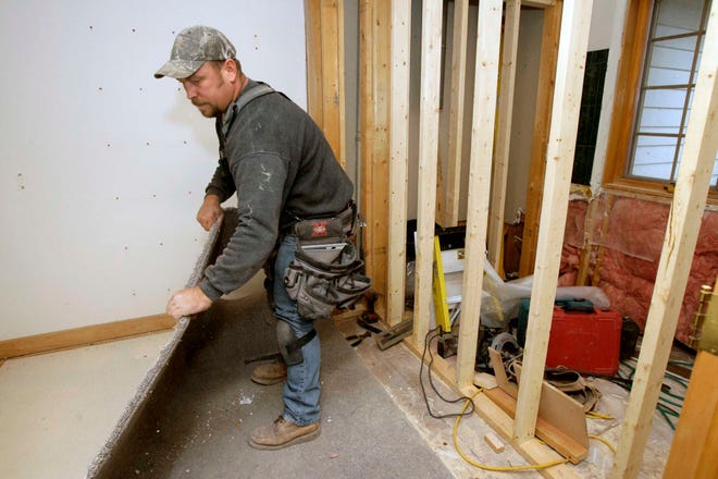 Tom Engelkes of Bob Logan Remodeling pulls out carpet Thursday, Dec. 2, 2010, while remodeling a bathroom and closet in a Rockford home.