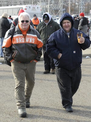Youngstown Ursuline fans, Joe Moretti (left) and Ted Terlesky, both from Austintown, make their way into Fawcett Stadium for the Division V state championship football game between Ursuline and Coldwater High School.