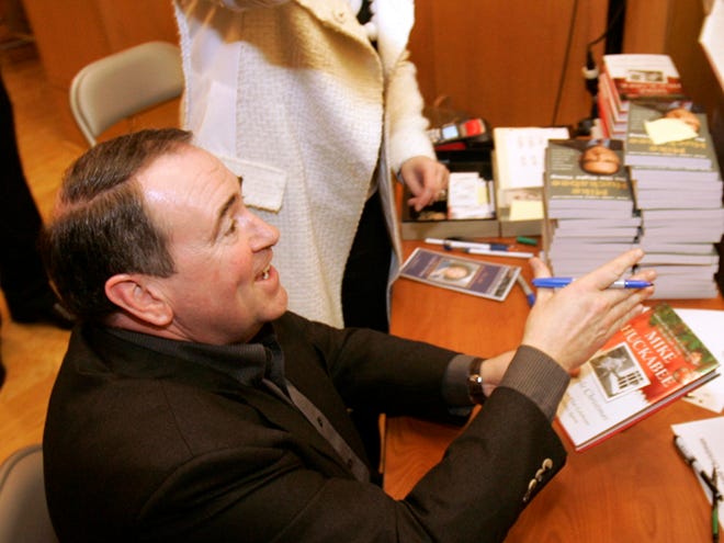 Former Arkansas Gov. Mike Huckabee, left, signs copies of his book "A Simple 
Christmas" in Little Rock, Ark. "What I was looking for was milestones in my 
life," Huckabee said of writing the book.ASSOCIATED PRESS