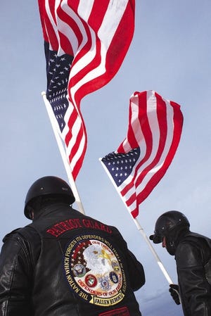 In a cold wind, Patriot Guards hold the American Flag as the Wreaths Across America program rides into Hampton Beach to place a wreath on the Marine Memorial before embarking to Arlington Cemetary Monday.
Rich Beauchesne photo