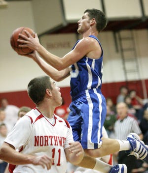Tuslaw's Nate Getz goes to the basket behind Northwest's Dan May during Tuesday night's game.