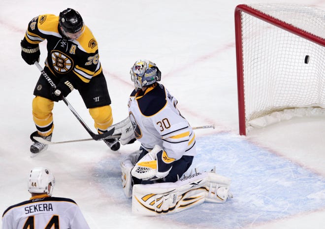 Boston Bruins right wing Mark Recch tips the puck past Buffalo Sabres goalie Ryan Miller to score the game-winning goal during overtime of an NHL hockey game in Boston, Tuesday, Dec. 7, 2010. The Bruins beat the Sabres 3-2.