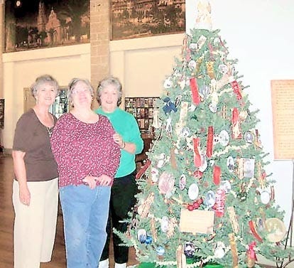 Glenda Delany Frawley, vice president of the Menorcan Cultural Society; Joyce Segui Marvick, board member; and Carol Lopez-Bradshaw, president, pose by the holiday tree. Contributed photo