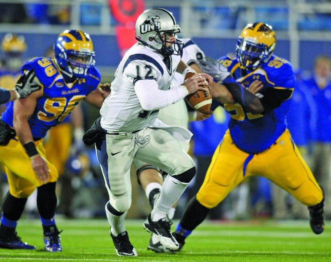 UNH quarterback R.J. Toman (center) scrambles for no gain as he is pursued by Delaware defensive end Chris Morales (left) and defensive lineman Siddiq Haynes (right).