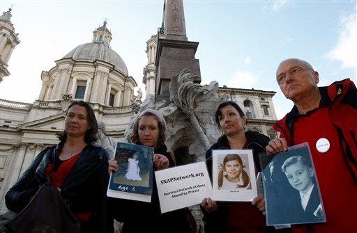 From right, Norbert Denef, Joelle Casteix, and Lucy Duckworth, members of support group for clergy abuse victims SNAP (Survivors Networks of those Abused by Priests), demonstrate holding pictures youngsters they claim were clergy abuse victims, in Piazza Navona Square, in Rome, Friday Nov. 19, 2010. WikiLeaks released Confidential U.S. diplomatic cables that indicate Ireland caved in to Vatican pressure to grant immunity to church officials in the investigation of decades of sex abuse by Irish clergy.