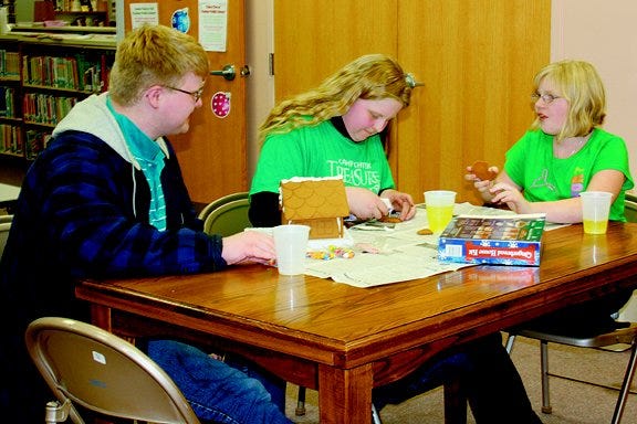 Pontiac Public Library held a gingerbread house competition recently. The winners, who were announced Friday, working away on their project. They are, from left, Levi Shawback, his sister, Eliza Shawback and Danielle Russell, all of Pontiac.