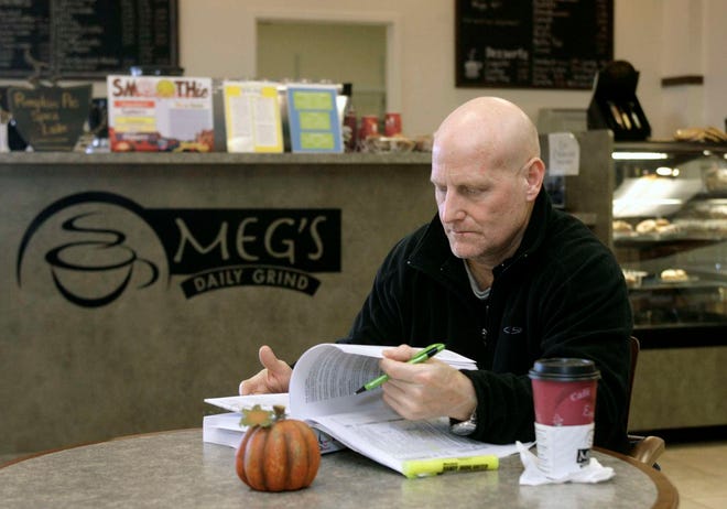 Chris Burns studies while having coffee Thursday, Nov. 18, 2010, at the Meg's Daily Grind inside the Rockford Public Library East Branch.